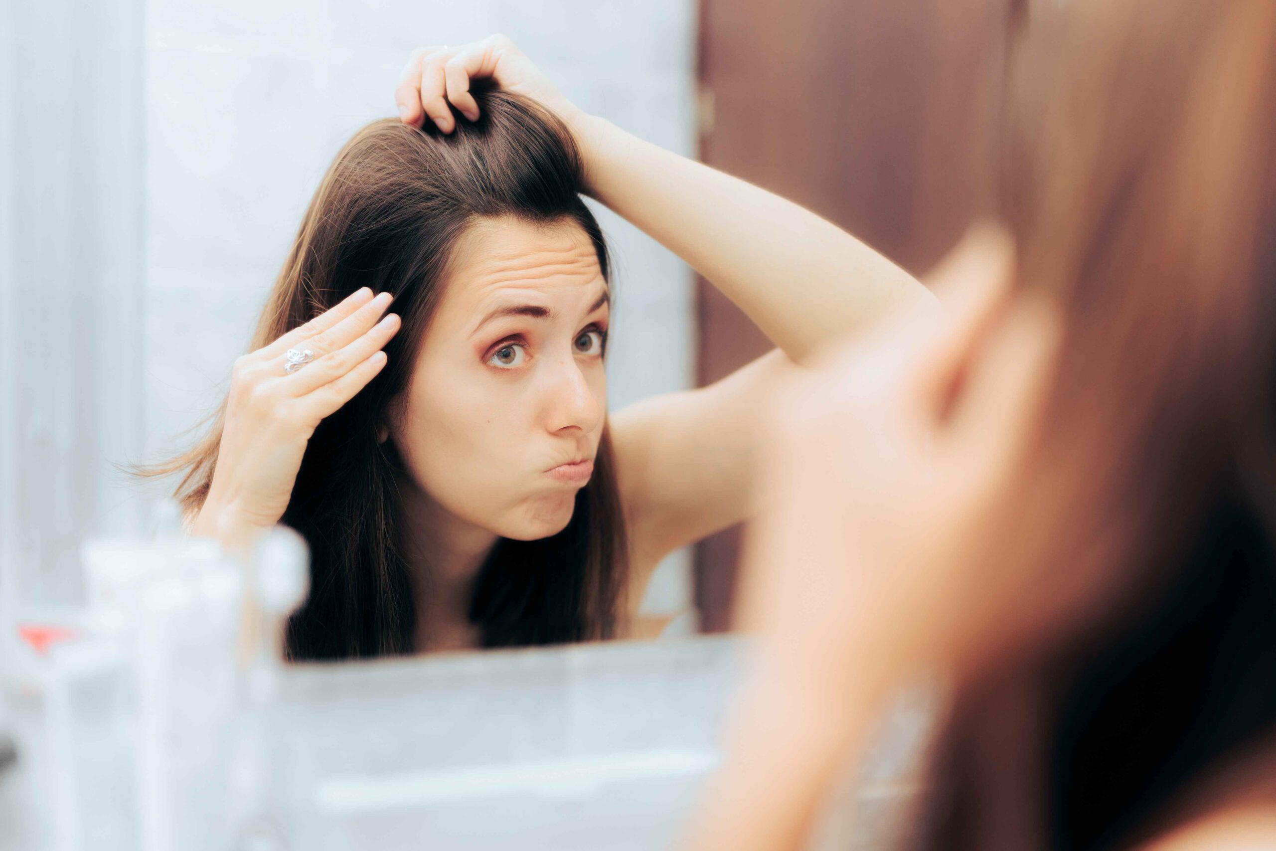 women fixing hair in bathroom